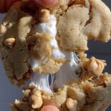 A person pulls a Peanut Pecan Fluffernutter cookie apart