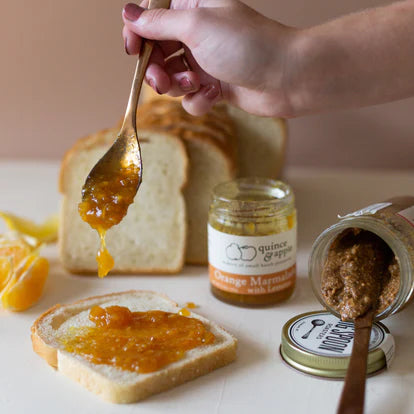 spooning orange maramalade onto toast