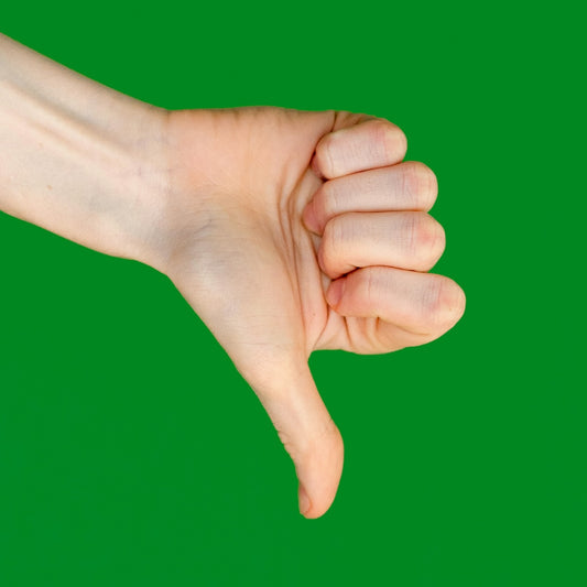 A thumb points down in front of a green background