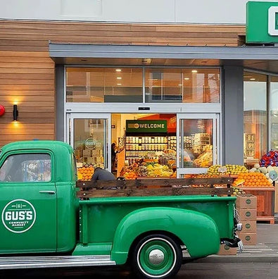 Gus's market exterior photo with green truck in front.