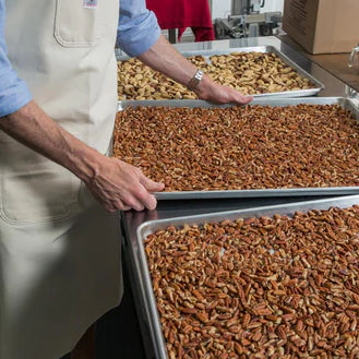 holding trays of roasted nuts