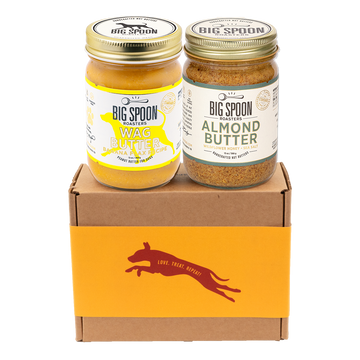 Two jars of Big Spoon Roasters nut butter - Banana Flax Wag Butter and Almond Butter with Wildflower Honey on a branded box 