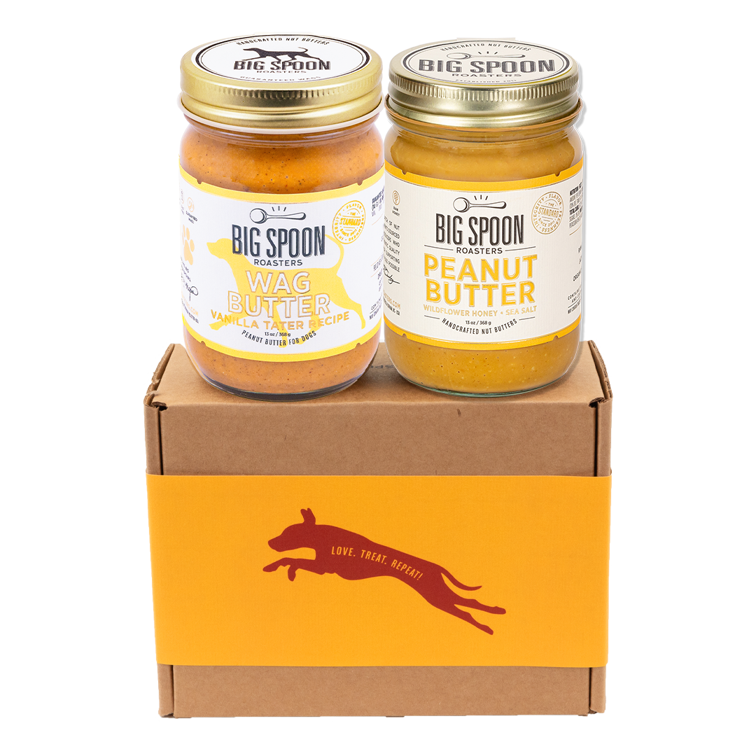 Jar of Vanilla Tater Wag Butter and a jar of Peanut Butter with Wildflower Honey on top of a gift box