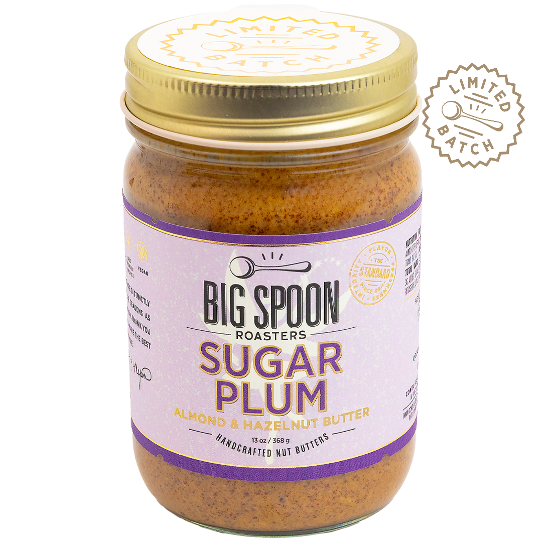 Jar of Big Spoon Roasters Sugar Plum almond and hazelnut butter with a gold lid on a white background.