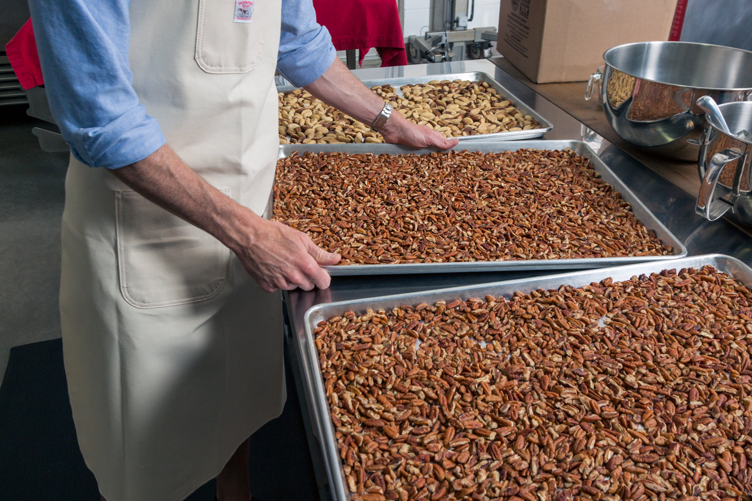 A Big Spoon Roasters artisan roasting nuts on sheet pans.