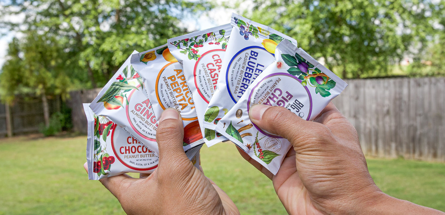 hand holding a variety of nut butter bars