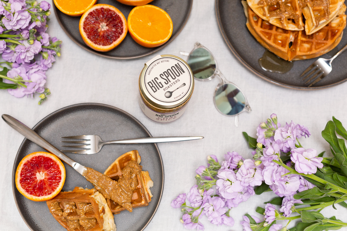brunch spread with waffles, Chai Spice Peanut & Almond Butter, citrus, flowers, and sunglasses