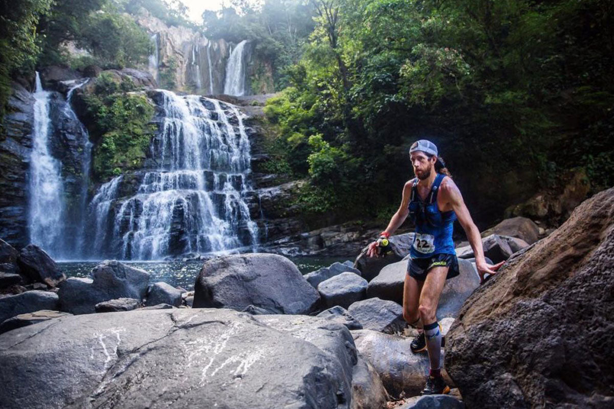 Mike Wardian trail running in front of a waterfall